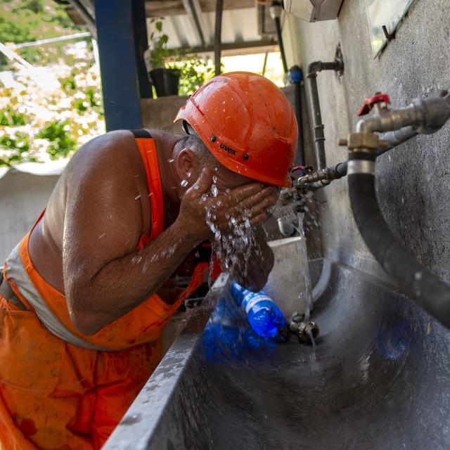 Ein Bauarbeiter einer Strassenbaustelle kuehlt sich bei einem Wasserhahn ab, am Donnerstag, 27. Juni 2019, in Lugano. Heute wurden im Tessin bis 38 Grad Celsius gemessen. (KEYSTONE/Ti-Press/Francesca Agosta) [Keystone - Francesca Agosta]