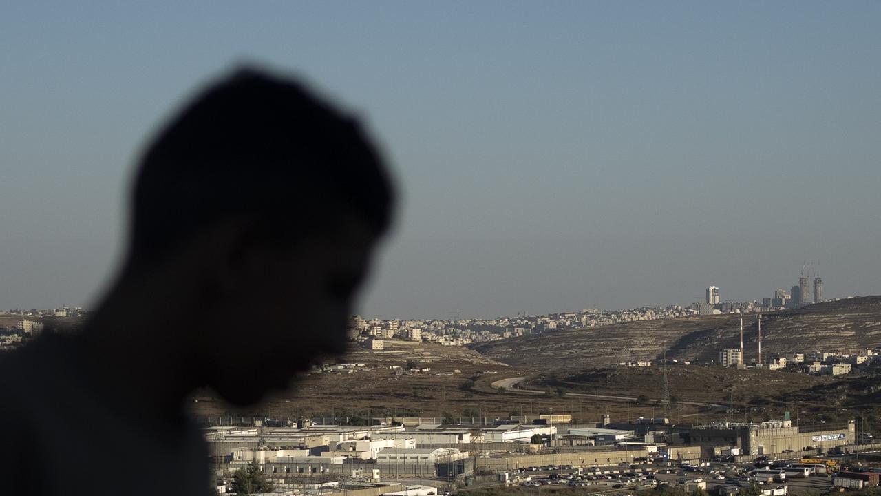 A Palestinian youth stands on a hill overlooking Israel's Ofer Prison, near the West Bank city of Ramallah, Wednesday, July 3, 2024. Released Palestinians have described to The Associated Press worsening abuses in Israeli prisons crammed with thousands detained since the war in Gaza began 10 months ago. [AP Photo/Keystone - Maya Alleruzzo]