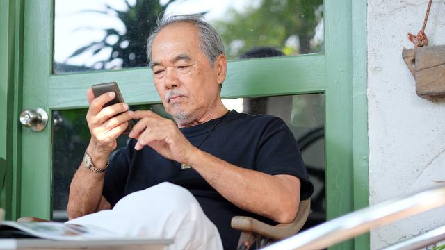 Un homme âgé avec un téléphone portable. [Depositphotos - ponsulak]