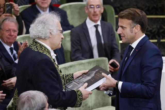 Le président français Emmanuel Macron reçoit la 9ᵉ édition du Dictionnaire de l'Académie Française des mains de son secrétaire perpétuel, l'écrivain franco-libanais Amin Maalouf. Paris, le 14 novembre 2024. [AFP - LUDOVIC MARIN]