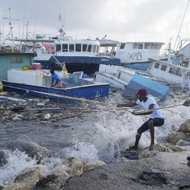 Des pêcheurs ramènent un bateau endommagé par l'ouragan Béryl au quai de Bridgetown Fisheries à la Barbade, le lundi 1er juillet 2024. [Keystone]