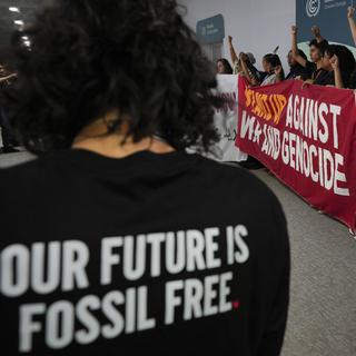 Des jeunes manifestants pour la justice climatique et un cessez-le-feu à Gaza, en Cisjordanie et au Liban lors d'une action à l'ouverture de la COP29 en Azerbaïdjan. [Keystone/AP Photo - Peter Dejong]