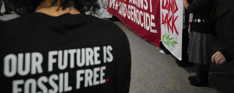 Des jeunes manifestants pour la justice climatique et un cessez-le-feu à Gaza, en Cisjordanie et au Liban lors d'une action à l'ouverture de la COP29 en Azerbaïdjan. [Keystone/AP Photo - Peter Dejong]