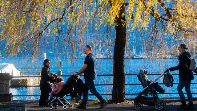 Des personnes se promènent au bord du lac à Locarno. [Keystone - Ti-Press/Samuel Golay]