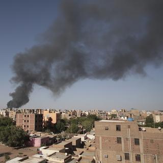 De la fumée s'échappe de la ville de Khartoum, au Soudan, le mercredi 19 avril 2023 [Keystone]