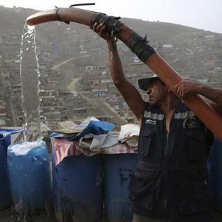 Un homme remplissant un conteneur d'eau, dans le bidonville de Nueva Esperanza, à Lima, au Péru, le 21 mars 2019 (photo d'illustration). [Keystone - Martin Mejia]