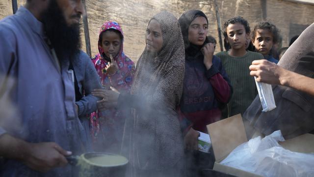 Des Palestiniennes et des Palestiniens attendent une distribution alimentaire à Deir al-Balah, dans la bande de Gaza. [KEYSTONE - ABDEL KAREEM HANA]