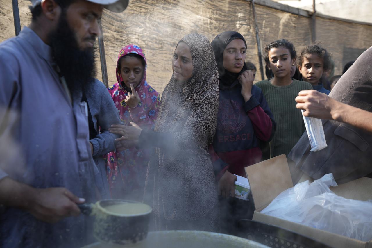 Des Palestiniennes et des Palestiniens attendent une distribution alimentaire à Deir al-Balah, dans la bande de Gaza. [KEYSTONE - ABDEL KAREEM HANA]