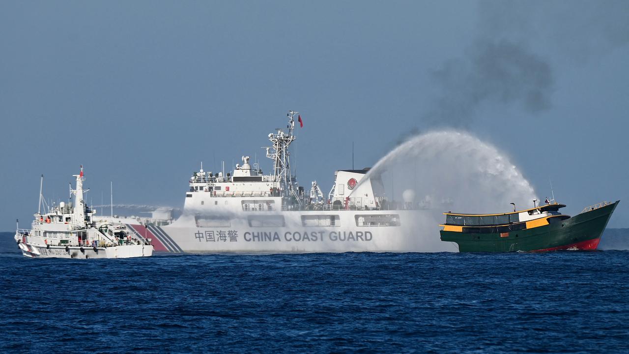 Des navires des garde-côtes chinois déployant des canons à eau vers des embarcations philippines en mer de Chine méridionale. [AFP - JAM STA ROSA]