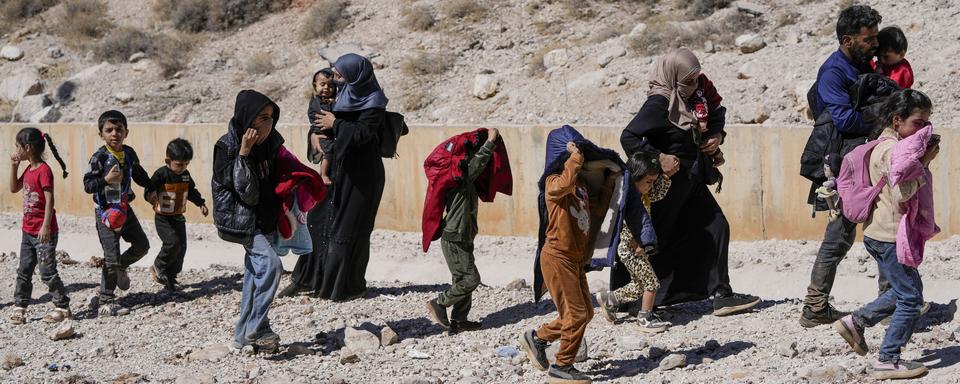 Plusieurs familles fuient le Liban à pieds vers la Syrie pour échapper à l'armée israélienne (image d'illustration). [Keystone/AP Photo - Hassan Ammar]