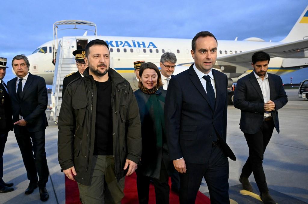 Le président ukrainien Volodymyr Zelensky est accueilli par le ministre français des Forces armées Sébastien Lecornu après avoir atterri à l'aéroport d'Orly, près de Paris. [AFP - BERTRAND GUAY]