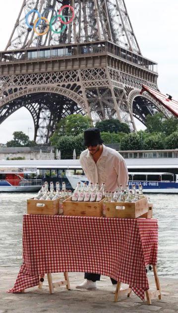 James Colomina s'est installé au bord de la Seine, non loin de la Tour Eiffel pour vendre ses bouteilles d'eau "finement polluée". [James Colomina]