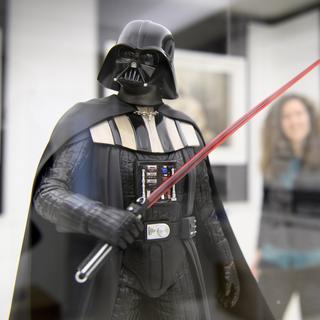 Une personne regarde une figurine Dark Vador de l'artiste Attakus dans le cadre de la nouvelle exposition de la Maison d'Ailleurs, "Je suis ton pere !" ce mercredi 6 decembre 2017 a Yverdon. 13 artistes revisitent l'univers de Star Wars dans le cadre de l'exposition "Je suis ton pere!" qui se deroule du 10 decembre 2017 au 14 octobre 2018. [Keystone - Laurent Gillieron]