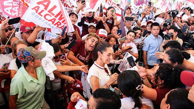 La candidate présidentielle du parti au pouvoir, Claudia Sheinbaum (au centre), salue ses partisans lors d'un événement politique dans la ville de Leon, dans l'État de Guanajuato, au Mexique. [KEYSTONE - LUIS RAMIREZ]