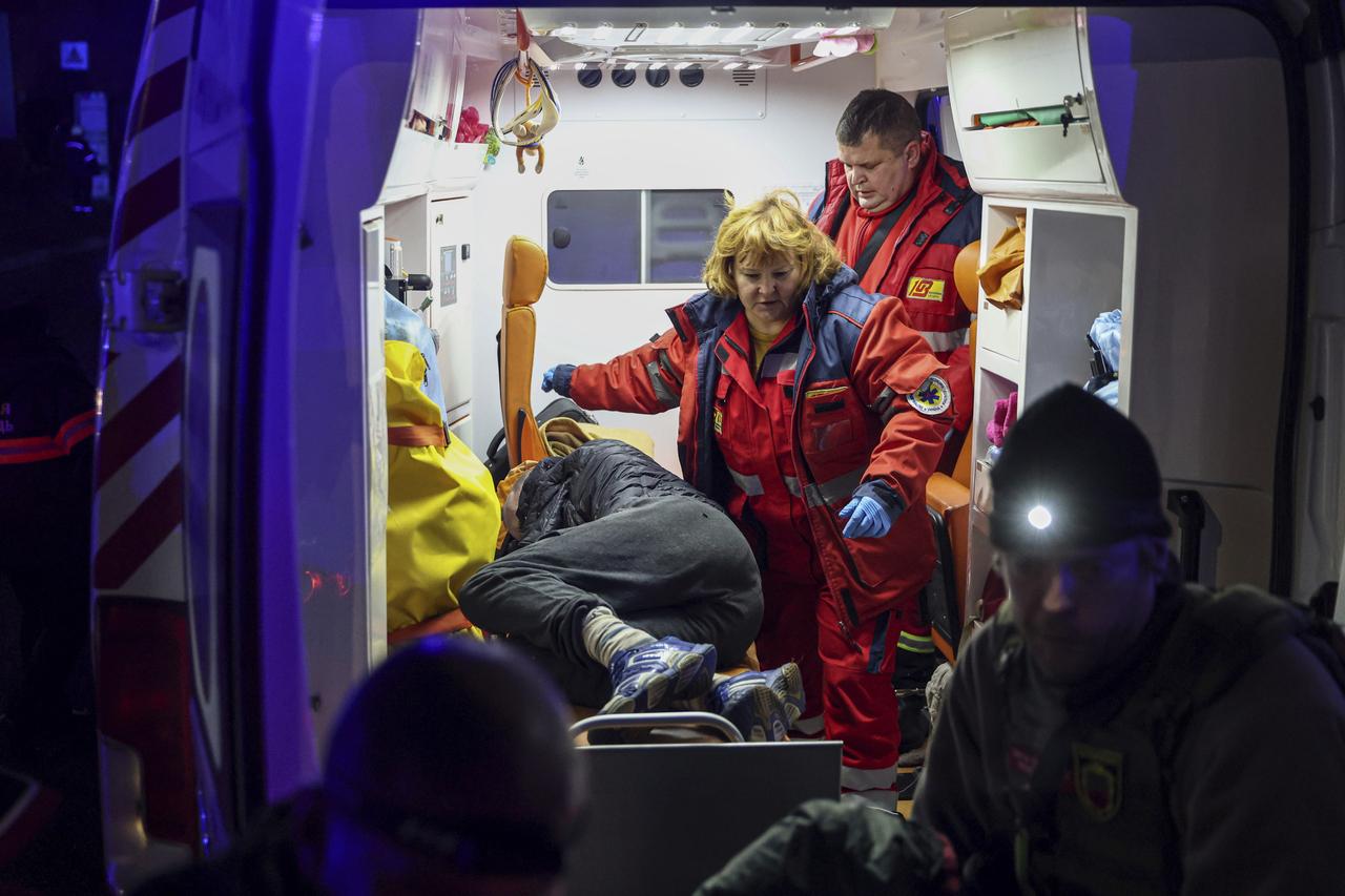 Des ambulanciers paramédicaux prodiguent les premiers soins à un homme blessé par une frappe russe à Zaporizhia, en Ukraine, le 6 décembre 2024. [KEYSTONE - KATERYNA KLOCHKO]