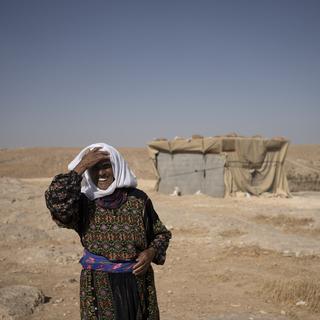 Une femme âgée palestinienne prend la pose devant sa maison à Masafer Yatta à Gaza. [Keystone/AP Photo - Maya Alleruzzo]