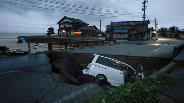 Une voiture prisonnière d'une route effondrée en raison de fortes pluies à Suzu, dans la préfecture d'Ishikawa, au Japon, le 21 septembre 2024. [KEYSTONE - JIJI PRESS]