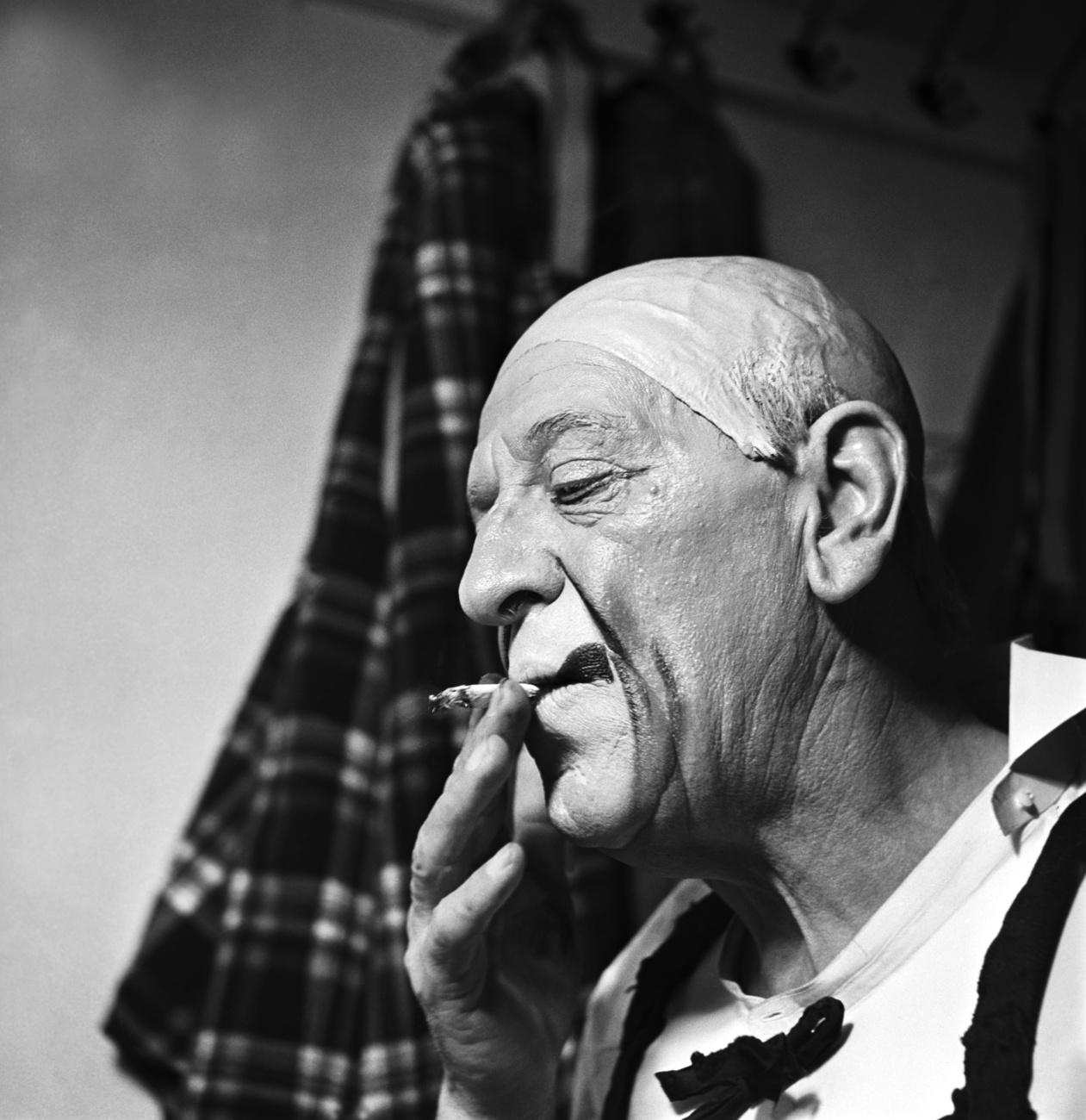 Sur cette photo non datée, le clown Grock fume une cigarette avant de monter sur scène. [KEYSTONE - STR]