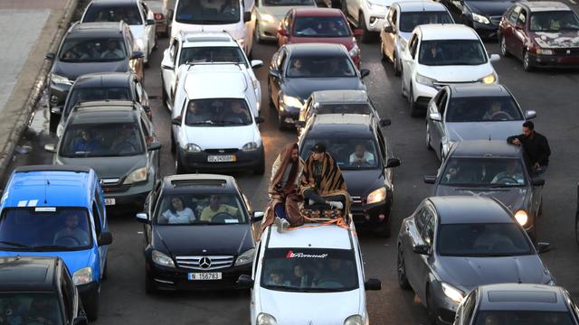 Lebanese citizens who fled the southern villages amid ongoing Israeli airstrikes Monday, sit on their cars at a highway that links to Beirut city, in the southern port city of Sidon, Lebanon, Tuesday, Sept. 24, 2024. [AP Photo/Keystone - Mohammed Zaatari]