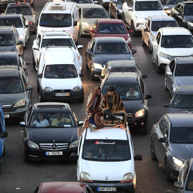 Lebanese citizens who fled the southern villages amid ongoing Israeli airstrikes Monday, sit on their cars at a highway that links to Beirut city, in the southern port city of Sidon, Lebanon, Tuesday, Sept. 24, 2024. [AP Photo/Keystone - Mohammed Zaatari]