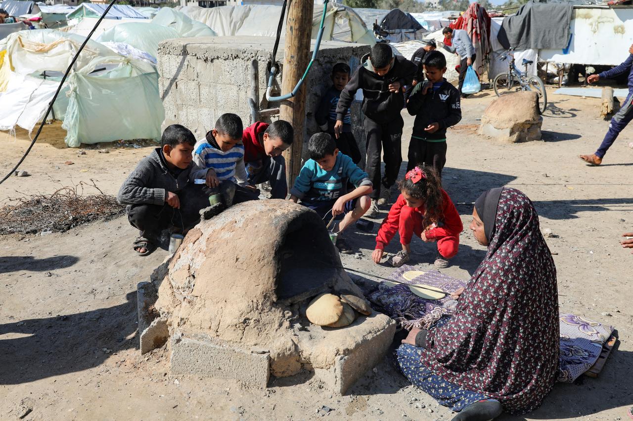 Une Palestinienne cuit du pain pour des enfants à Khan Younès, dans le sud de la Bande de Gaza. [Reuters - Arafat Barbakh]