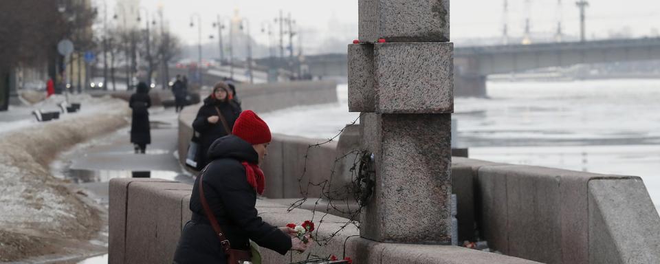 Une personne dépose des fleurs devant un mémorial pour Alexeï Navalny. [Keystone - EPA/Anatoly Maltsev]