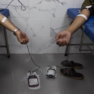 Des Palestiniens donnent du sang dans l'hôpital Nasser du camp de Khan Younès à Gaza. [Keystone/EPA - Haitham Imad]