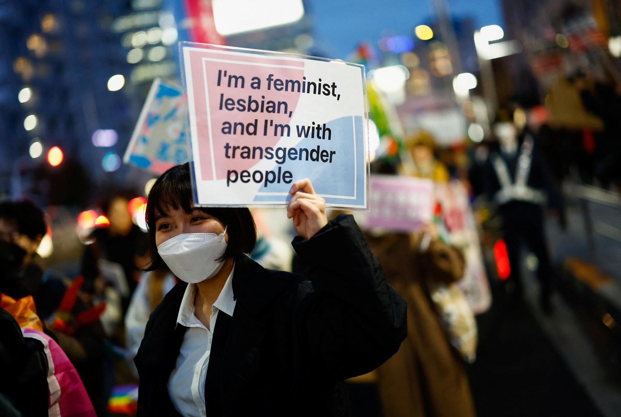 Une manifestante a Tokyo lors de la journée des droits de la femme le 8 mars 2024 portant le message "Je suis féministe, lesbienne, et je suis avec les personnes transgenres". [Reuters - Issei Kato]