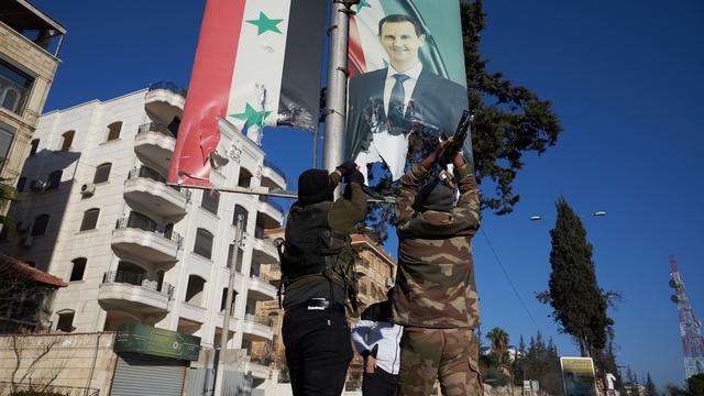 Des rebelles démontent un portrait de Bachar al-Assad à Alep. [KEYSTONE - KARAM AL-MASRI]