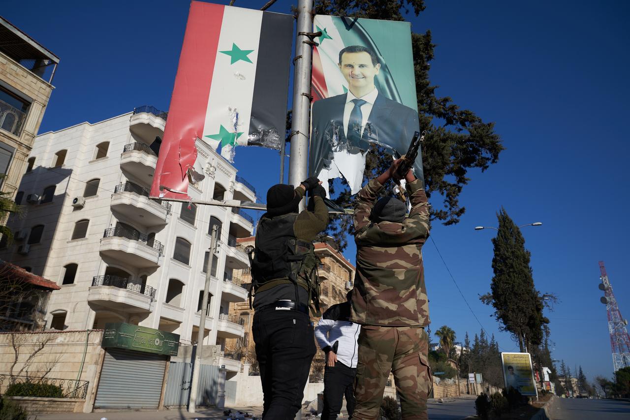 Des rebelles démontent un portrait de Bachar al-Assad à Alep. [KEYSTONE - KARAM AL-MASRI]