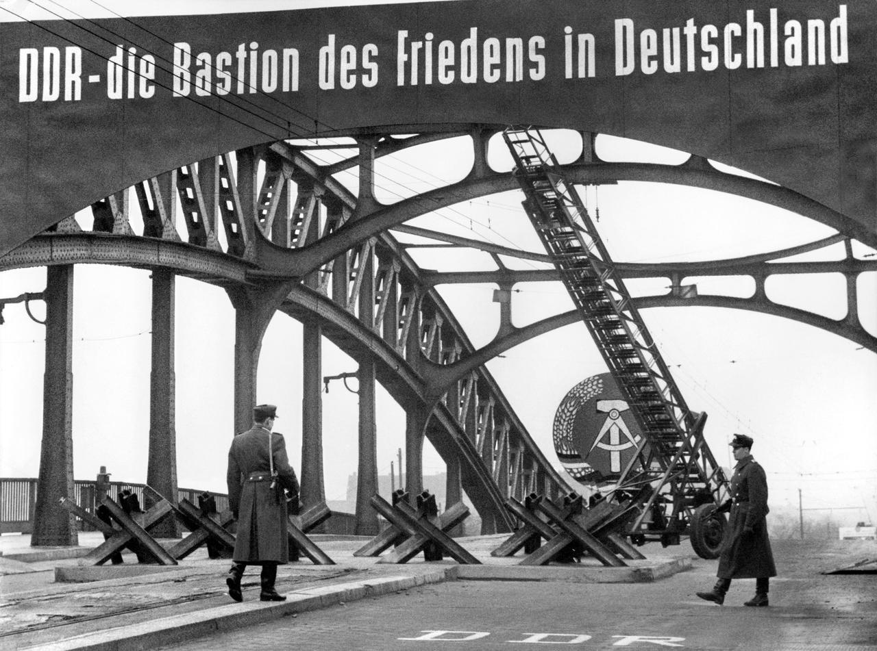 Le 4 décembre 1961, des "policiers du peuple" surveillent le passage de la Bornholmer Strasse sur le pont de la Boesebruecke, entre le secteur français et le secteur soviétique de Berlin. [KEYSTONE - STR]