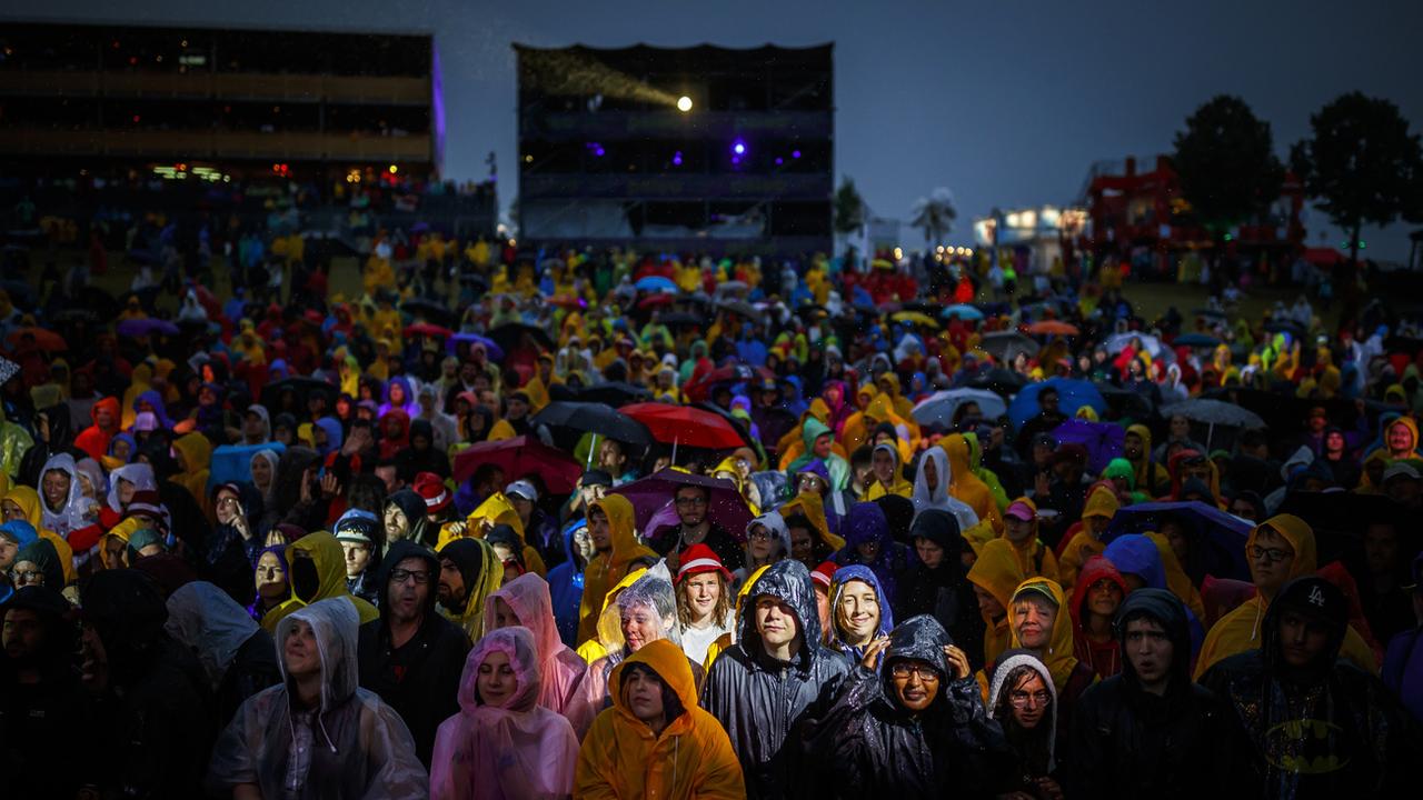 Des festivaliers et festivalières sous la pluie devant la Grande Scène de Paléo en 2018. [Keystone - Valentin Flauraud]