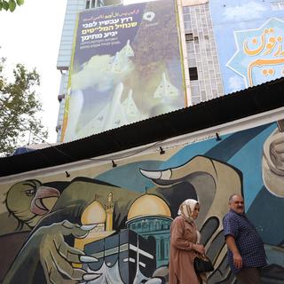 Un couple devant une image murale anti-Israël en Iran. [Keystone/EPA - Abedin Taherkenareh]