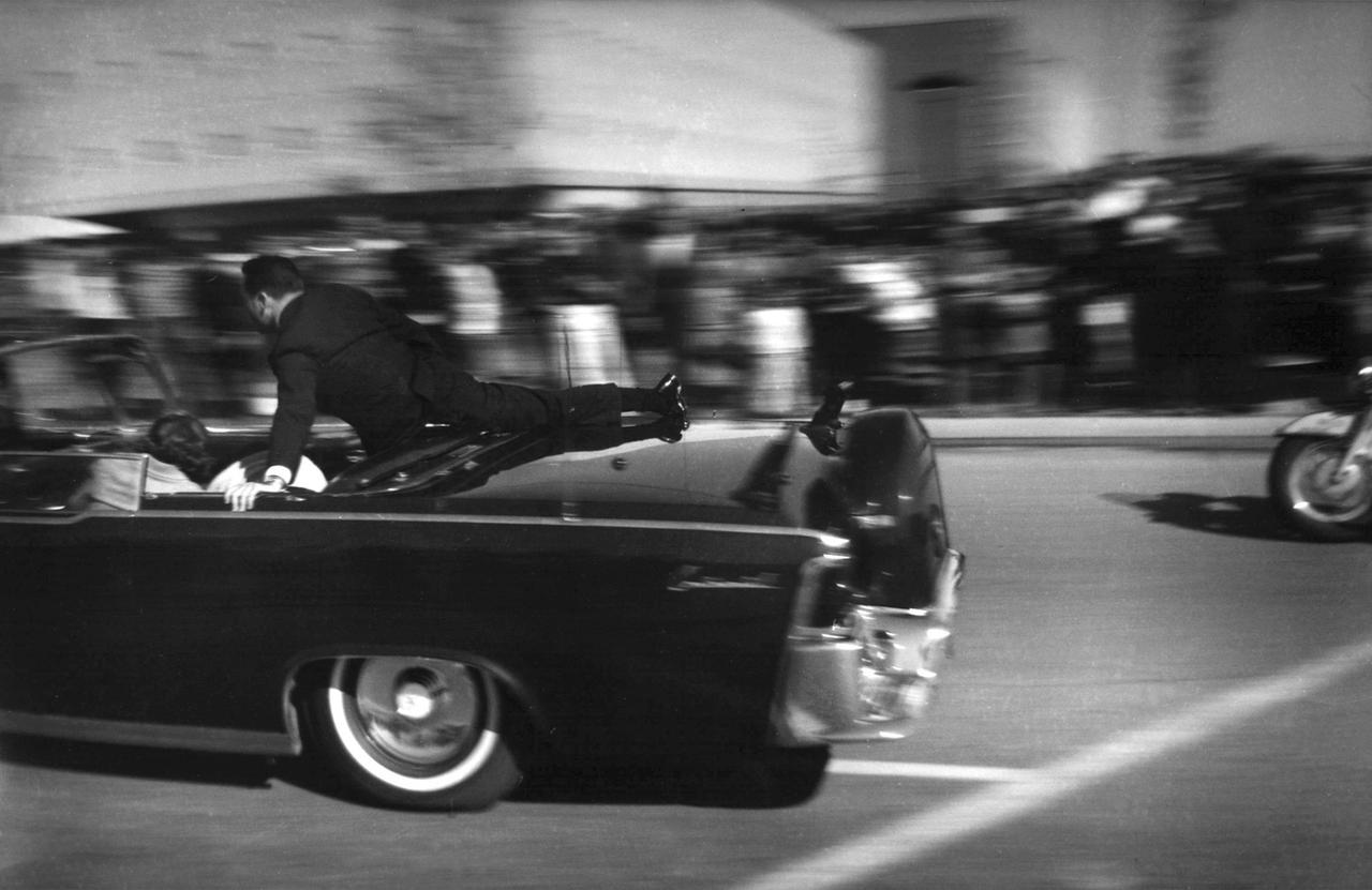 La limousine transportant le président John F. Kennedy, mortellement blessé, se dirige vers l'hôpital quelques secondes après qu'il a été abattu, le 22 novembre 1963, à Dallas. [KEYSTONE - Justin Newman]