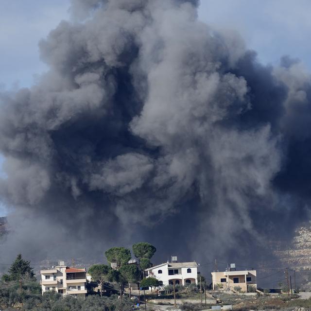 De la fumée noire monte dans le ciel après une frappe israélienne sur le village d'Aita al-Shaab, au Liban. [Keystone - Hussein Malla]