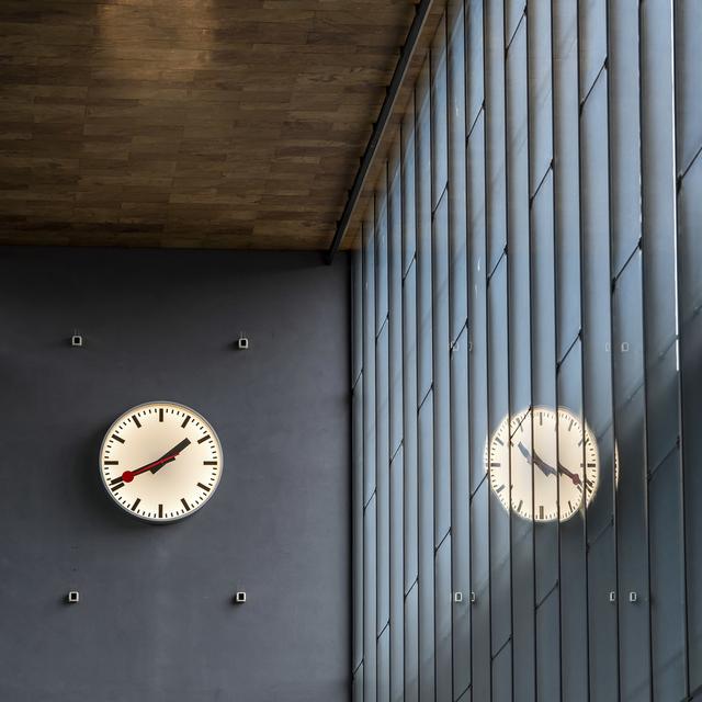 Une horloge des CFF se reflète à la gare Cornavin (GE). [Keystone - Martial Trezzini]