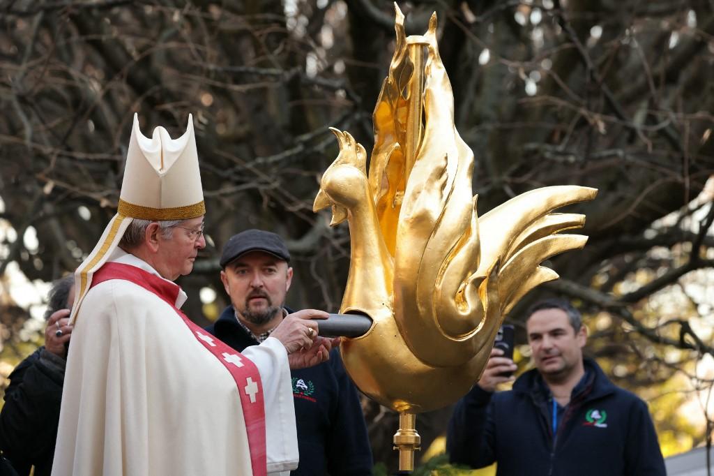 Le nouveau coq de la Cathédrale Notre-Dame au moment où l'archevêque de Paris y place les reliques sauvées du feu. [AFP - THOMAS SAMSON]