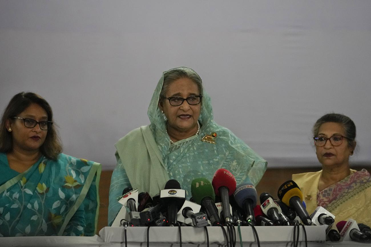 La Première ministre du Bangladesh, Sheikh Hasina, entourée de sa fille et de sa sœur, s’adresse aux médias le 7 janvier 2024. [KEYSTONE - ALTAF QADRI]