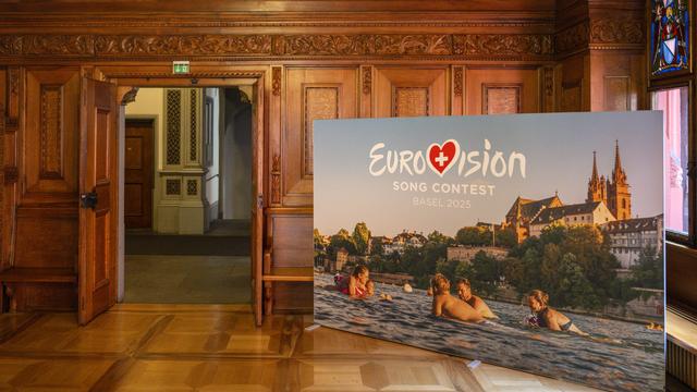 Une affiche avec le logo du Concours Eurovision de la Chanson (CEC) trône dans l'hôtel de ville de Bâle, le vendredi 30 août 2024, lors de la conférence de presse. [KEYSTONE - GEORGIOS KEFALAS]