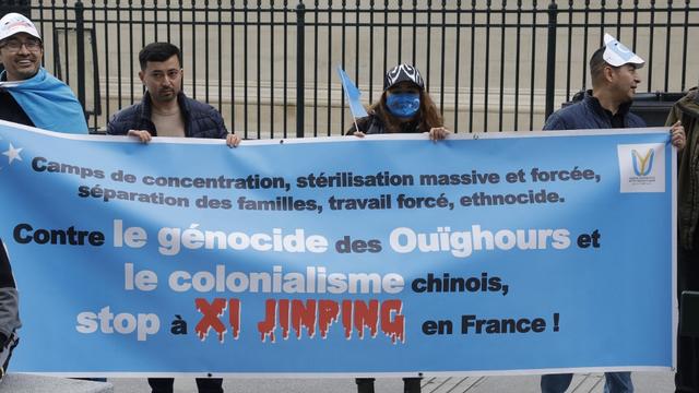 Des manifestants contre la visite d'Etat en France de Xi Jinping sur la place de la Madeleine à Paris. [AFP - Geoffroy Van der Hasselt]