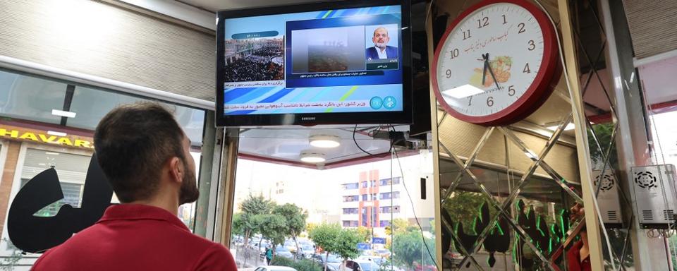 Un homme regarde les informations sur le décès d'Ebrahim Raïssi. [AFP - Atta Kenare]