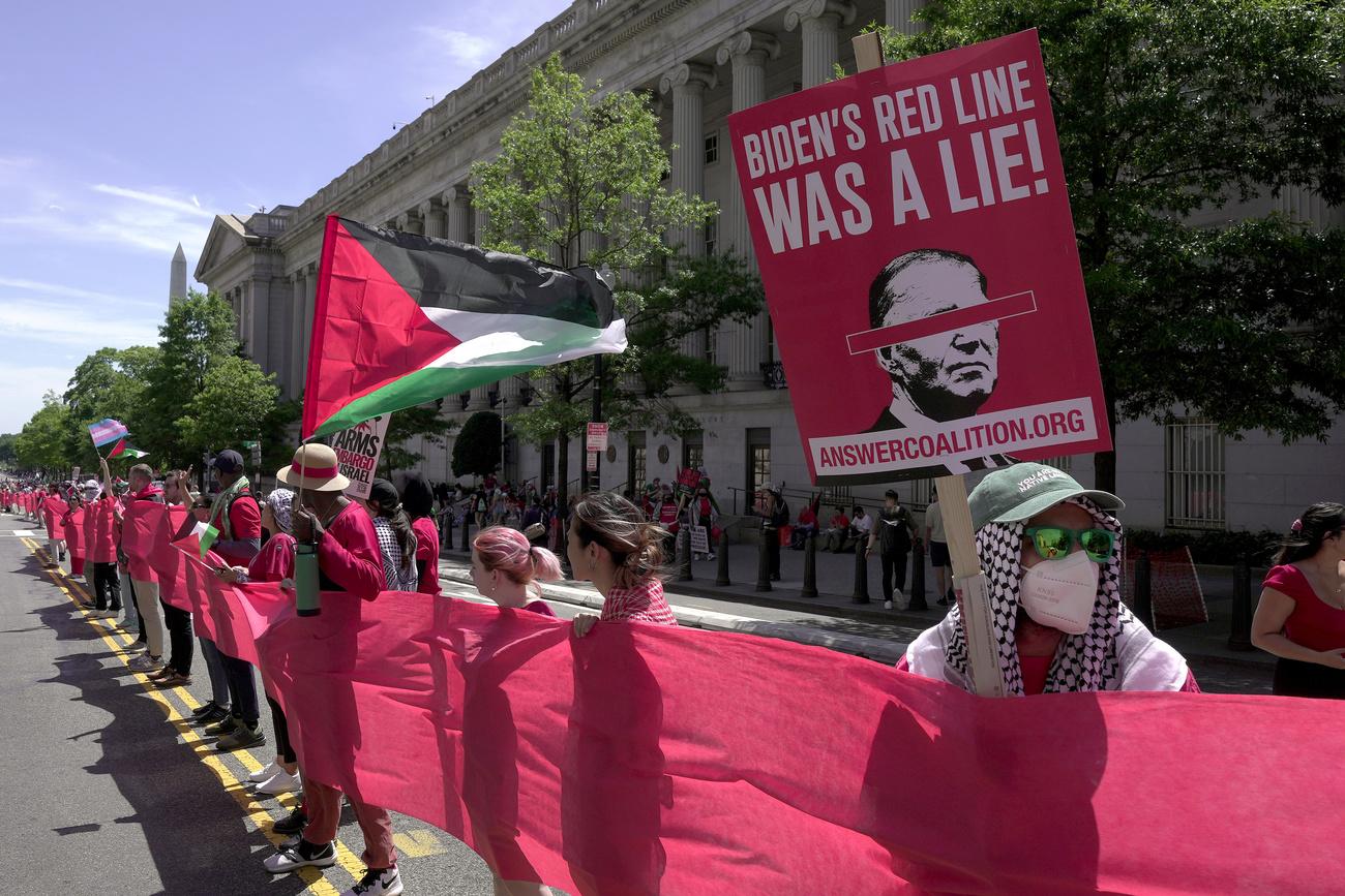 Les manifestants tenaient des drapeaux palestiniens et des pancartes affichant "la ligne rouge de Biden était un mensonge". [Keystone - Manuel Balce Ceneta - AP Photo]