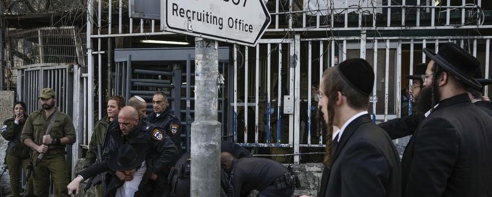 Des juifs ultra-orthodoxes protestent devant un centre de recrutement à Jérusalem contre l'extension du service militaire. [Keystone/AP Photo - Leo Correa]