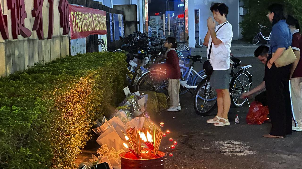 Des gens se recueillent à l'extérieur du "Zhuhai People's Fitness Plaza" où un homme a délibérément foncé avec sa voiture sur des personnes faisant de l'exercice dans le centre sportif, à Zhuhai, dans la province de Guangdong, dans le sud de la Chine, le mardi 12 novembre 2024. [Keystone - AP Photo/Ng Han Guan]