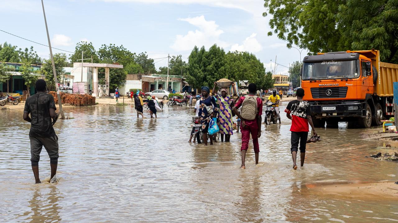 epa11558167 People walk in a flooded street in N'Djamena, Chad, 21 August 2024. Flooding caused by rainfall and strong winds have been affecting central and south-western Chad, according to the UN Office for the Coordination of Humanitarian Affairs (OCHA), which reported more than 5,300 displaced people, 261,000 people affected by floods and 16,200 damaged or destroyed houses from 15 July to 15 August 2024. EPA/CHANCELIN MBAIRAMADJI MOITA [Keystone/AP - Chancelin Mbairamadji Moita]