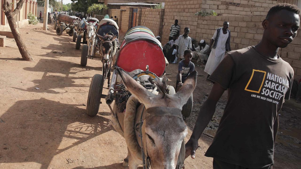 Un jeune noir sarcastique transporte de l'eau sur un âne. [Keystone/AP Photo - Marwan Ali]