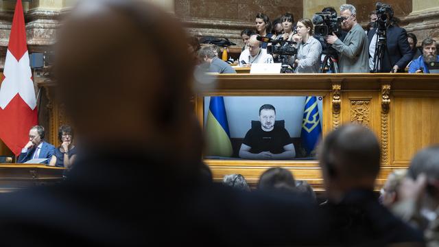 Le président ukrainien Volodymyr Zelensky est affiché sur un écran lors de son discours devant les membres du parlement suisse, à Berne, le 15 juin 2023. [KEYSTONE - PETER KLAUNZER]