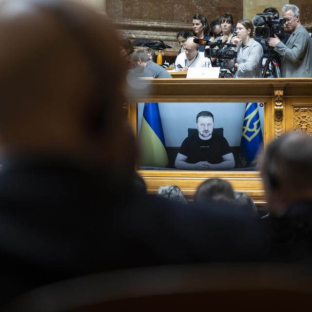 Le président ukrainien Volodymyr Zelensky est affiché sur un écran lors de son discours devant les membres du parlement suisse, à Berne, le 15 juin 2023. [KEYSTONE - PETER KLAUNZER]