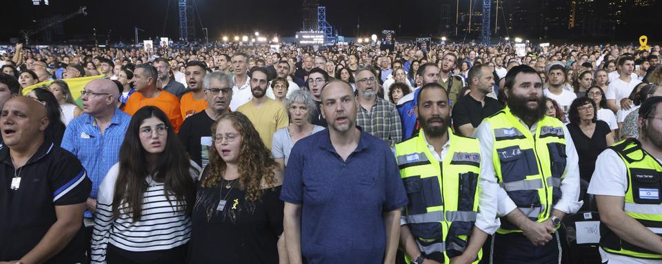 People sing as they attend an alternative memorial ceremony organised by the families of hostages held in Gaza, to mark a year since the Hamas attack on Israel, in a park in Tel Aviv, Israel, Monday, Oct. 7, 2024. (Jim Urquhart/Pool Photo via AP) [Keystone/AP/Pool Photo - Jim Urquhart]