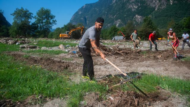 Des bénévoles sont à l’œuvre pour panser les plaies de Lostallo après le glissement de terrain. [KEYSTONE - SAMUEL GOLAY]